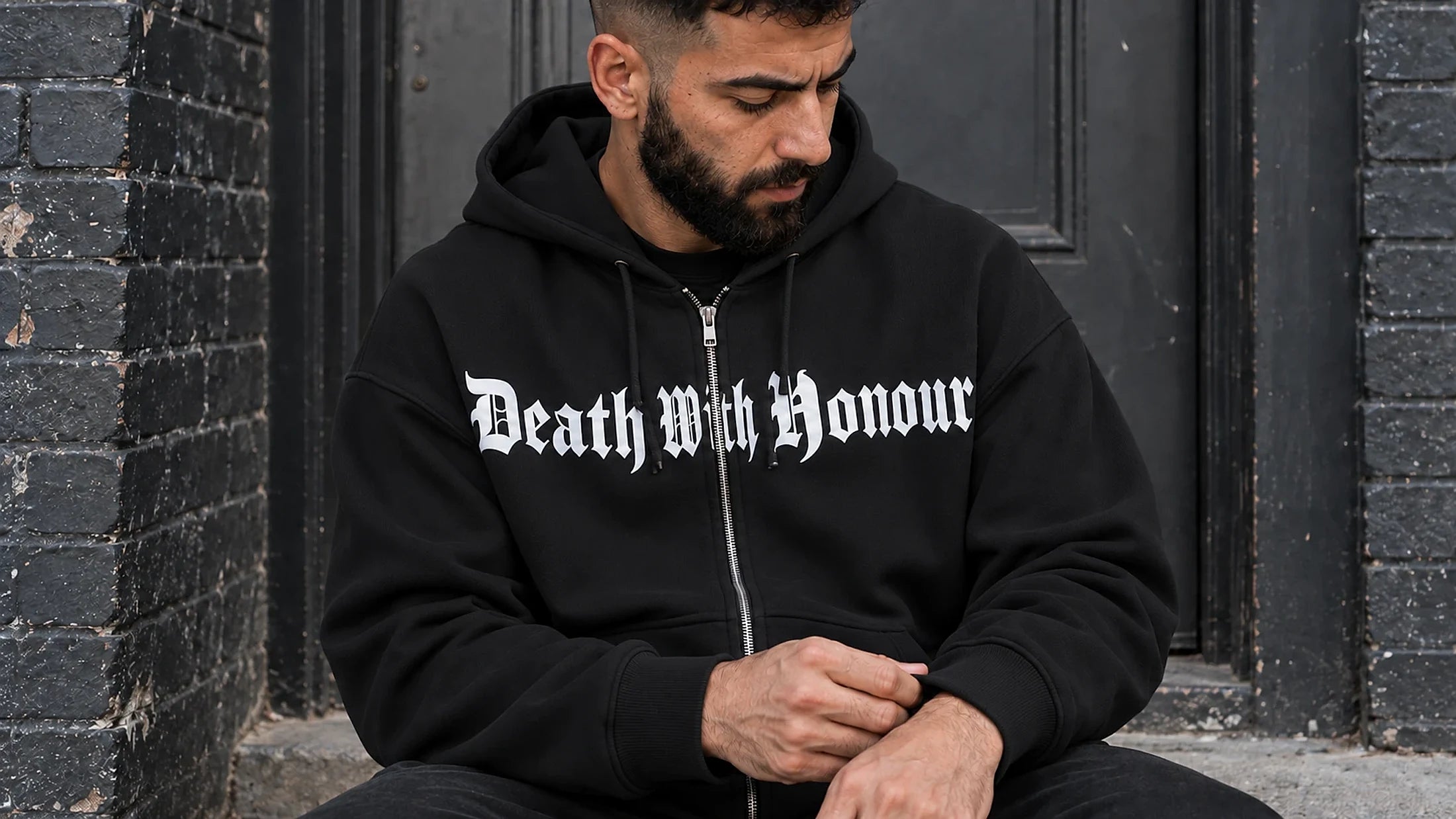 Death With Honour hoodie, seated in a doorway