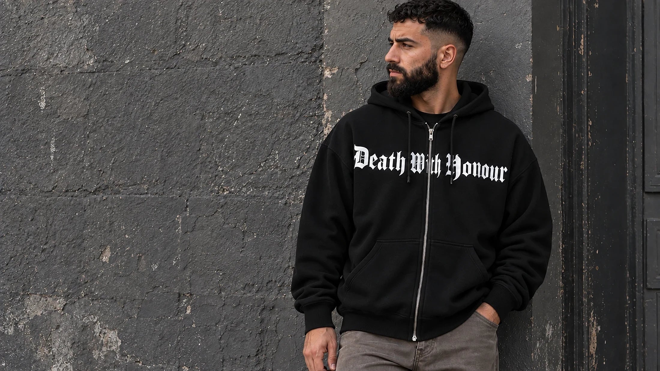 Death With Honour hoodie against a stone wall